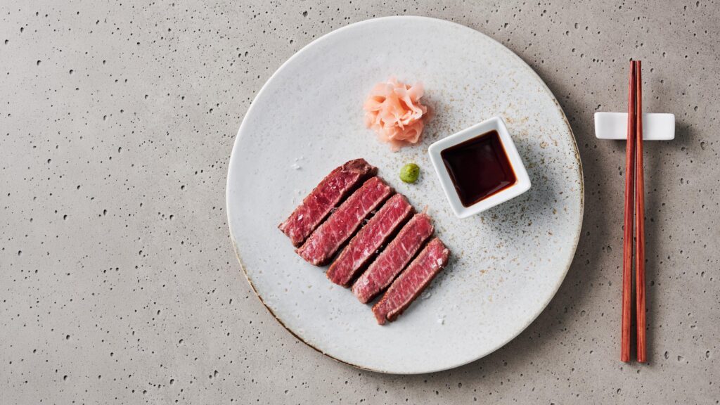Foodfotografie: Aufgeschnittenes Wagyu-Steak mit Sojasauce und Ingwer