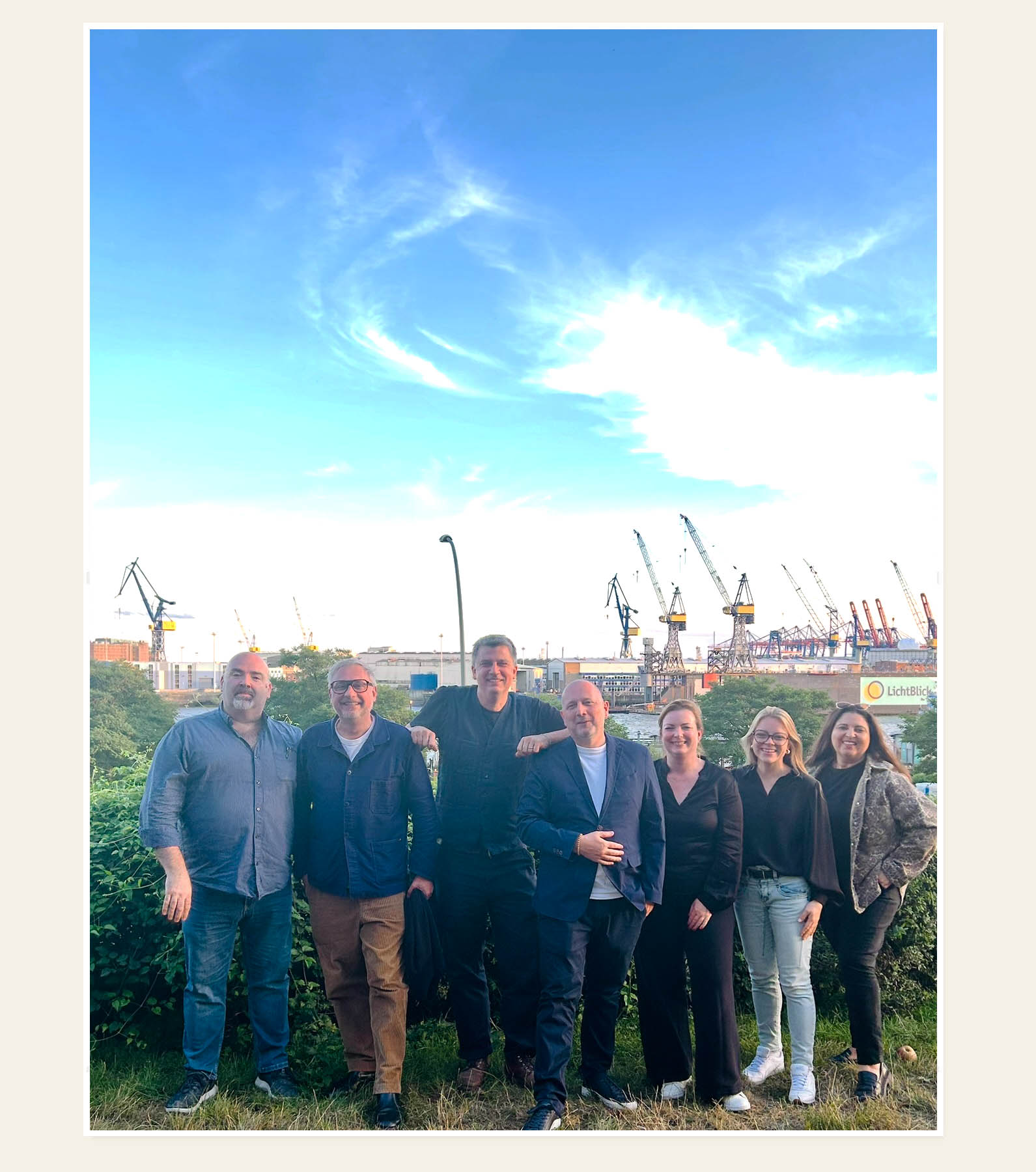 Internationale Pressegruppe mit Kaiserhappen vor dem Hamburger Hafen