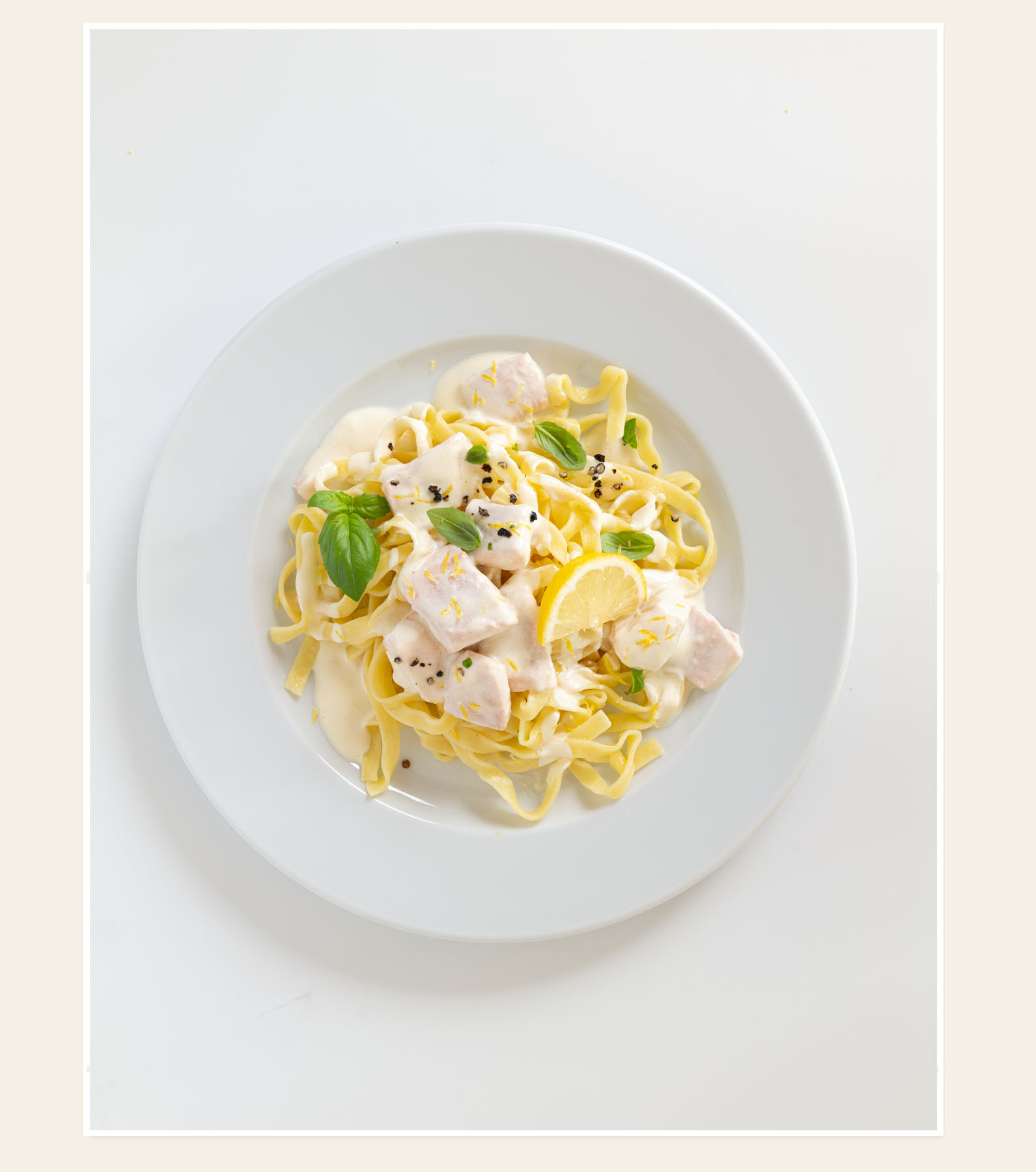 Pasta mit Hähnchen, Zitrone und Basilikum auf weißem Teller – Kaiserwetter Catering